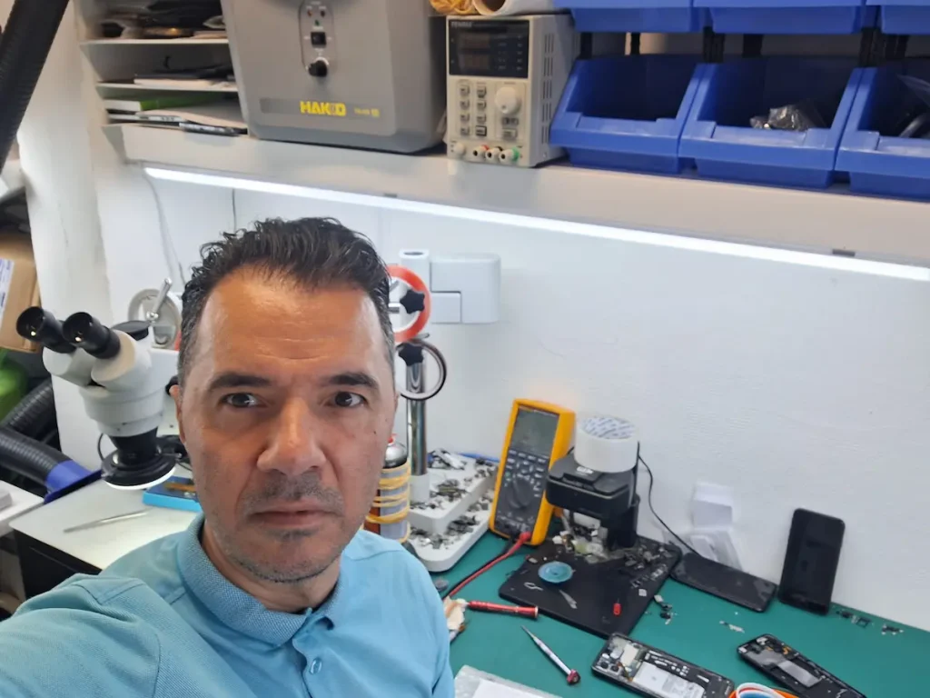 Tehnician Reparo GSM la bancul de lucru cu microscop – 25 de ani experiență în reparații telefoane București